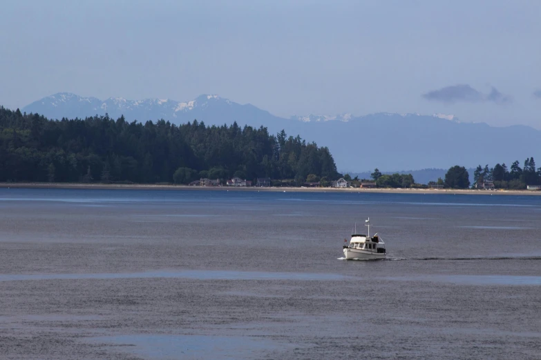 the fishing boat travels toward the shore on a calm day