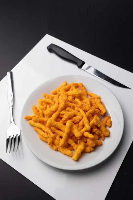 a plate topped with cheetos next to two forks