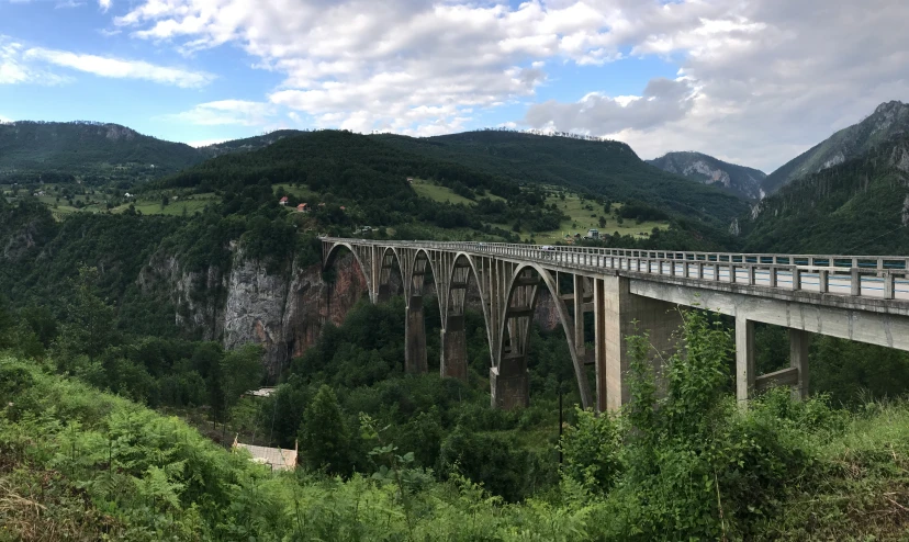 a bridge over a river surrounded by mountains