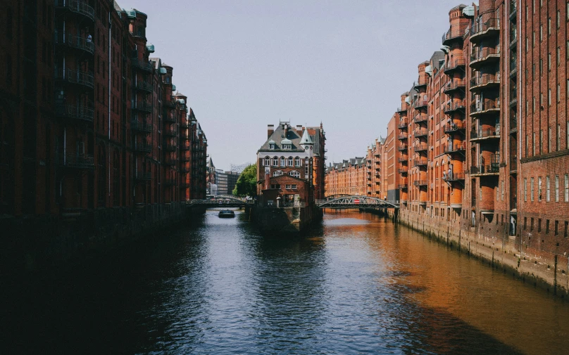 a long waterway surrounded by tall red brick buildings