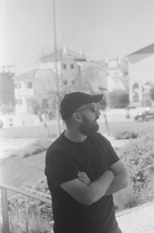 a man standing in a parking lot with his arms crossed