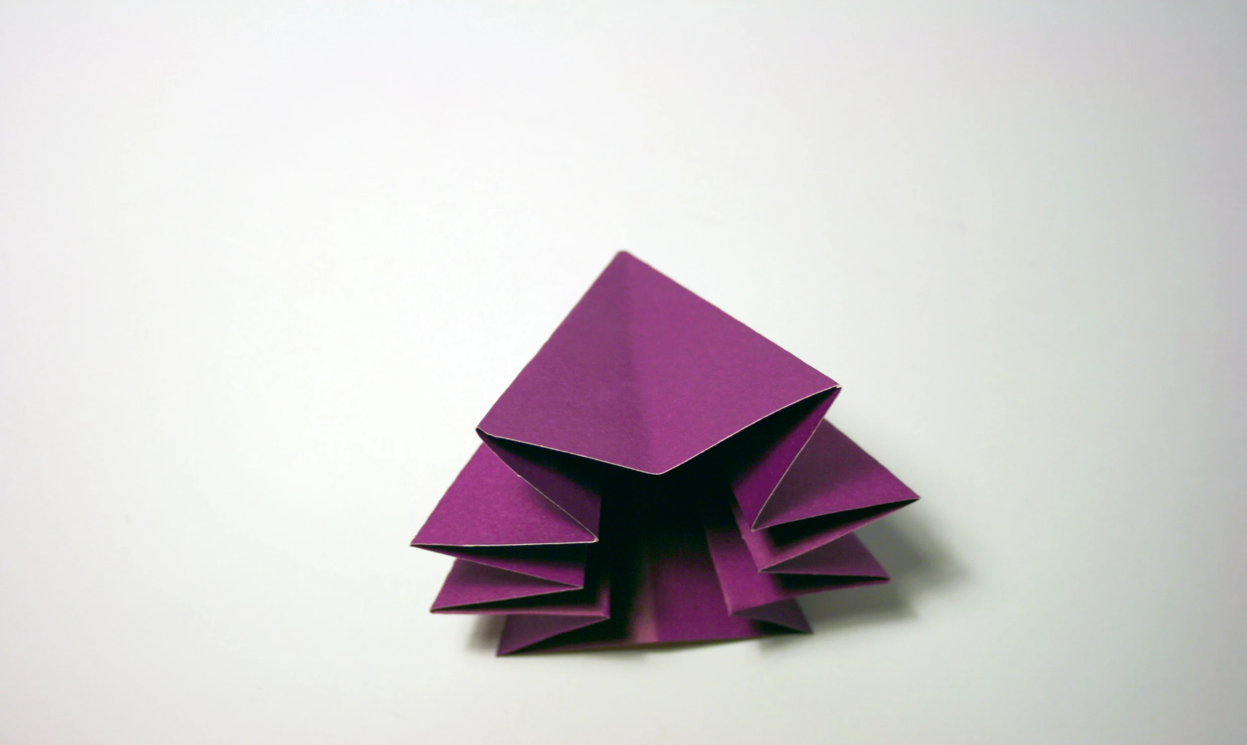 a purple paper triangle with one corner folded