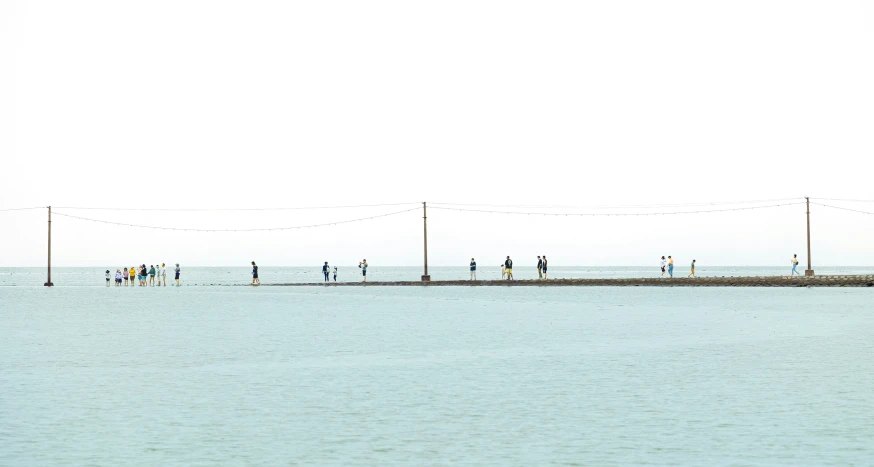 some people walk along a water way by the ocean