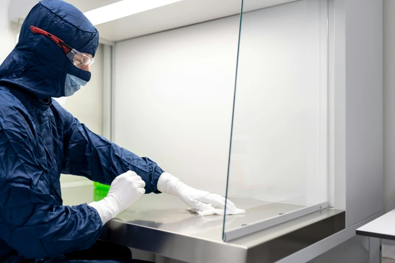 a man wearing a blue coverall and white gloves