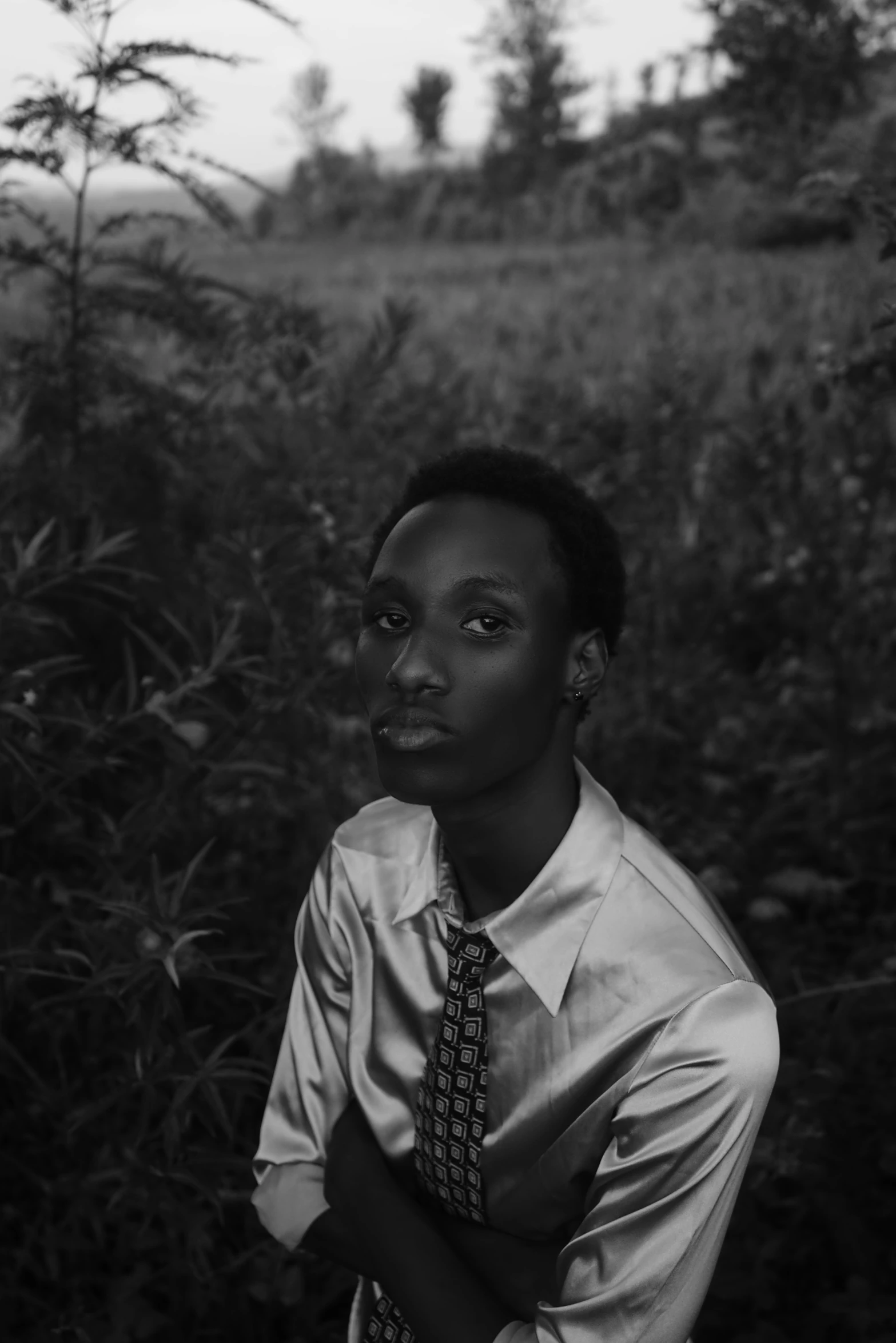 a man wearing a tie stands in the forest