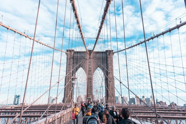 there is a crowd of people walking across the brooklyn bridge