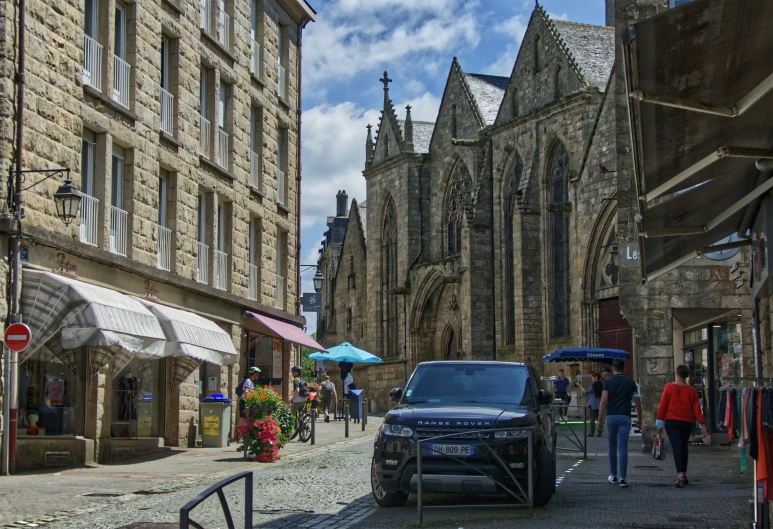 people walking down the street as cars are stopped