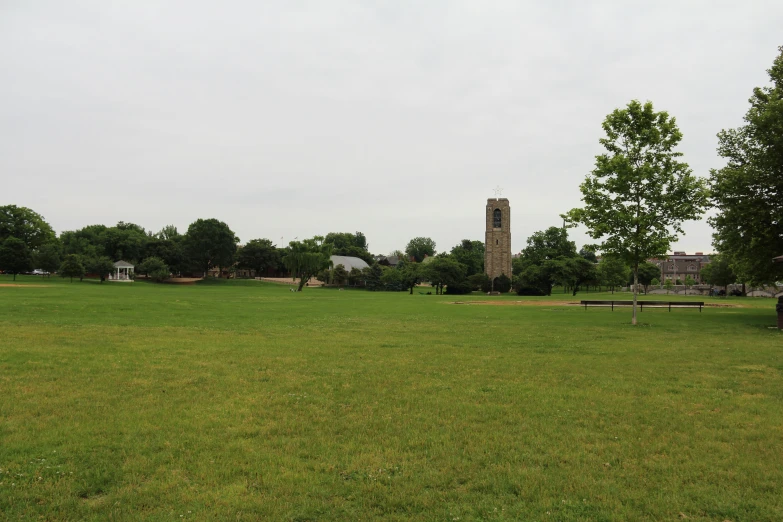 a clock tower is sitting near a grassy area