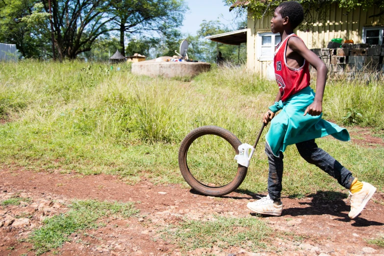 a young woman runs after her bike, near a small shack