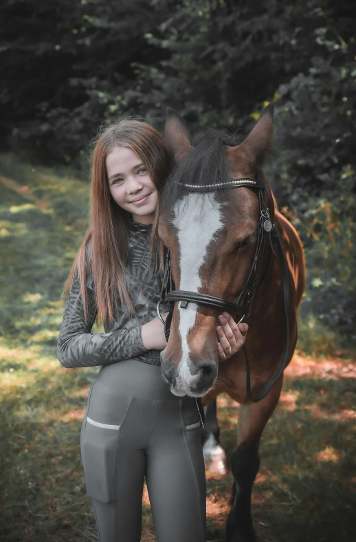 a woman is standing with her horse in the grass