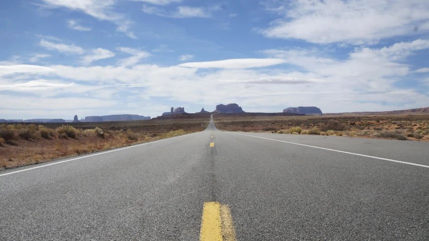 a long stretch of open highway stretches into a distant, distant, desert landscape