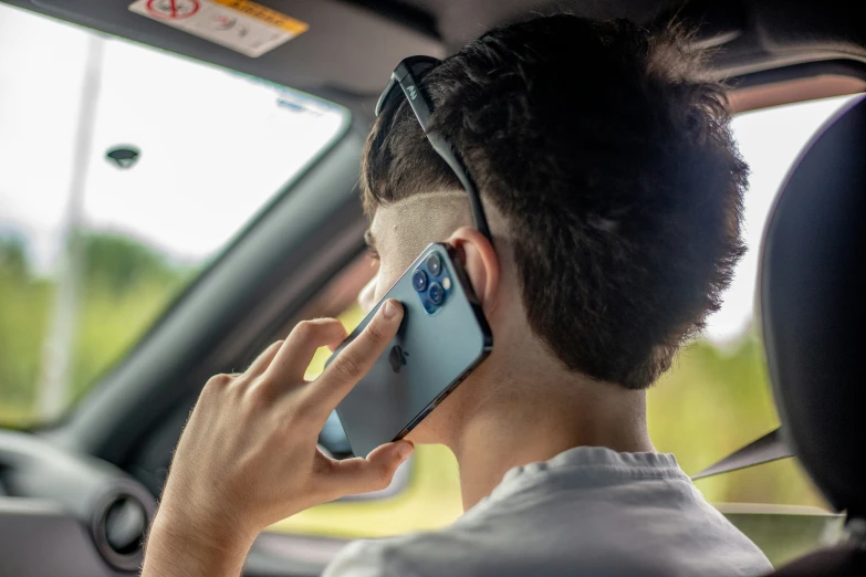 the man in his car using the cell phone while driving