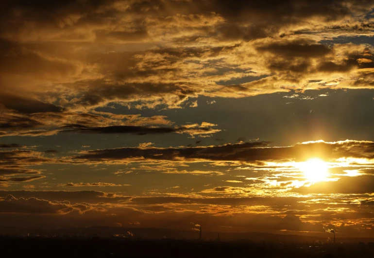 the sun setting in an orange colored sky