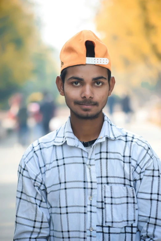 young man standing in the street wearing a hat with a name tag