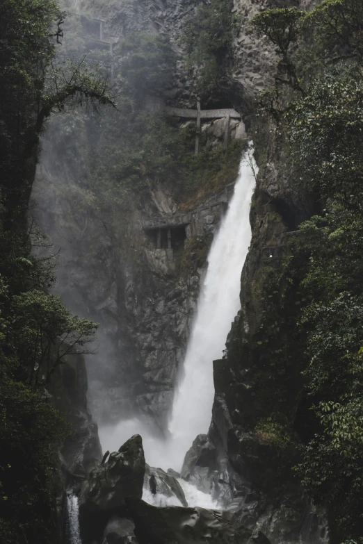 a river with a waterfall running between the mountains