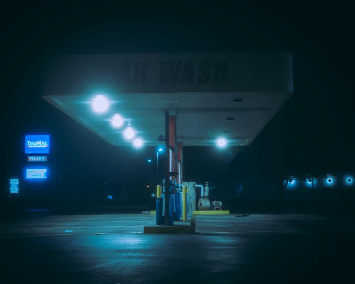 a gas station at night with blue neon lights