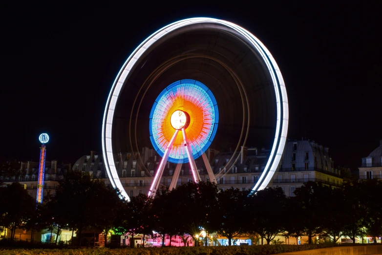 a bright ferris wheel lights up the night sky