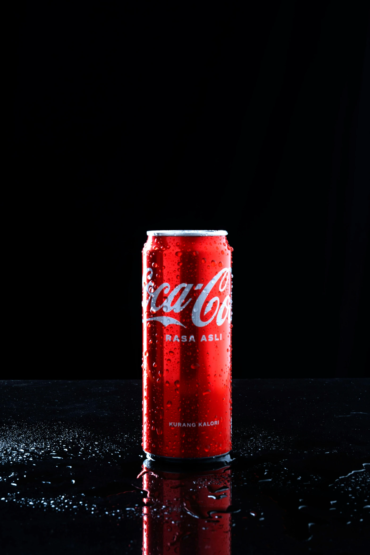 a red soda can sitting on top of a dark table