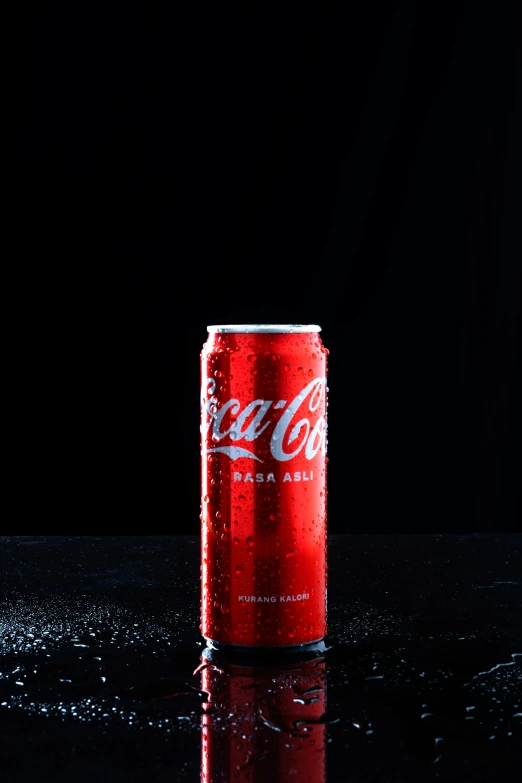 a red soda can sitting on top of a dark table