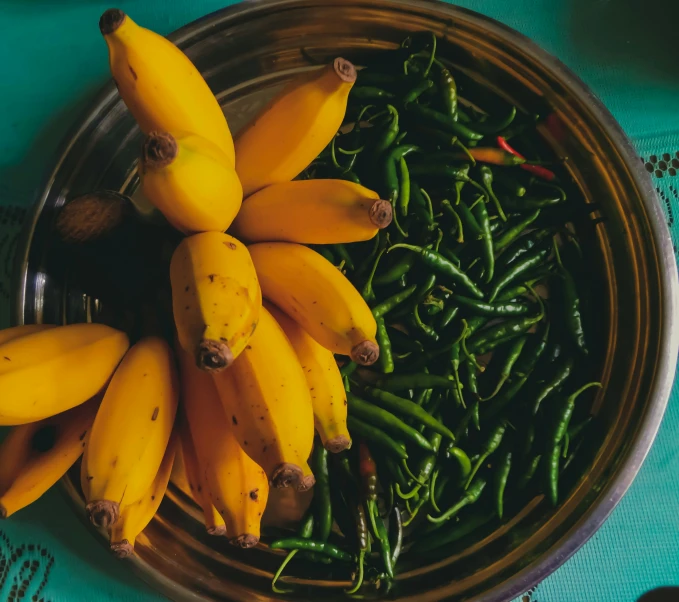 a metal bowl with bunches of bananas in it