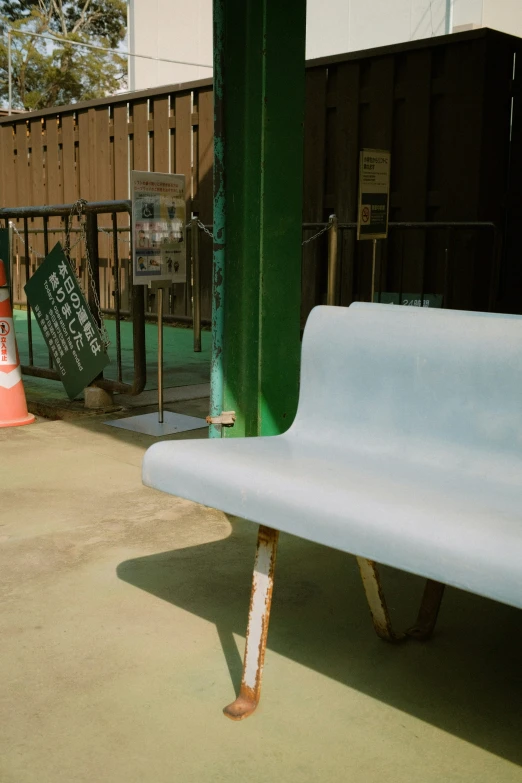 a white bench sitting on top of a sidewalk