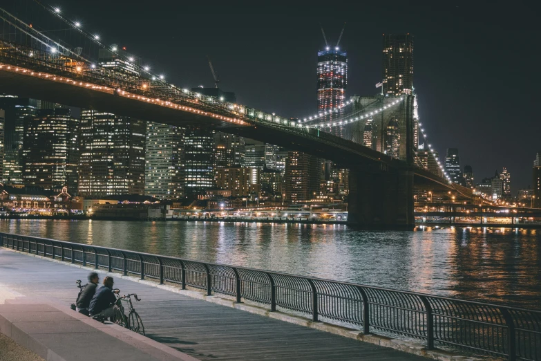 people riding their bikes over the water near a bridge