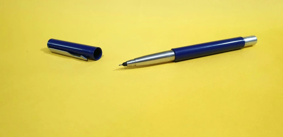 two pens are set on a yellow surface