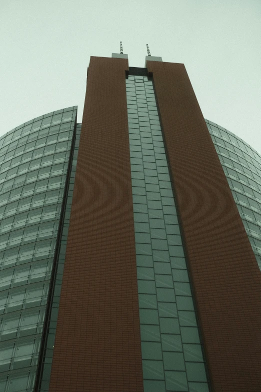 two tall, curved buildings are visible against the sky