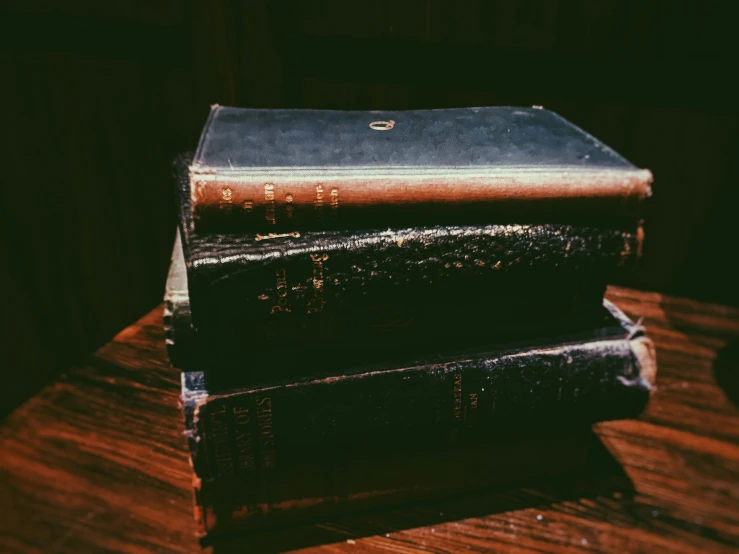 two old books sit next to each other on a table