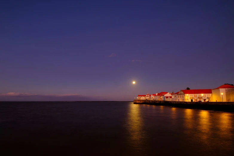 the light house has a bright white color in the night sky