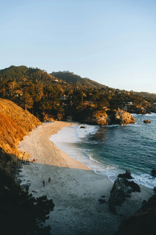 a beach has an sandy shoreline and hills in the background