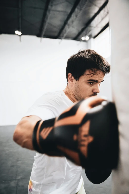 man standing next to punching bag in gym