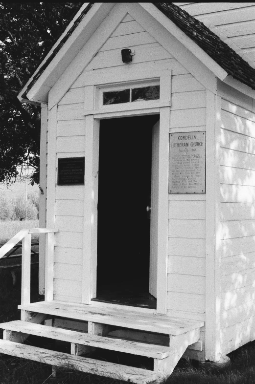 black and white pograph of an old out house