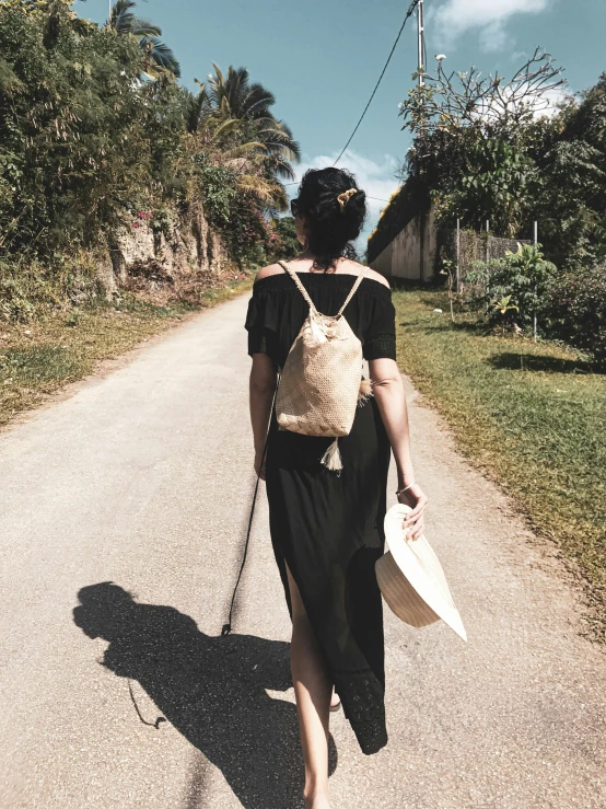 a woman with a big purse is walking down a narrow street