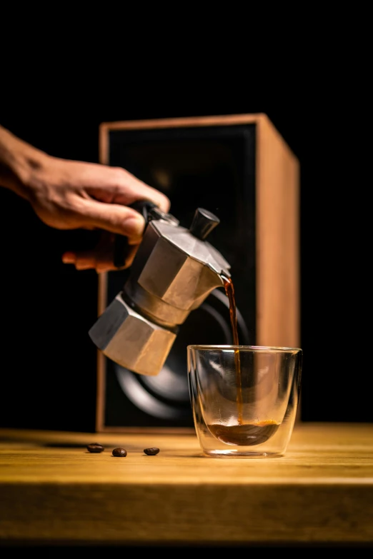 a person pours coffee from the mug into the glass