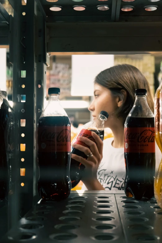 a woman holding a glass while looking at some bottles