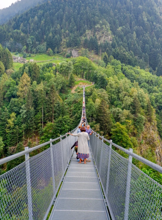 people walking across the tall metal walkway to reach a lookout point