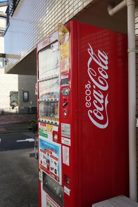 a red coke machine on the side of a building