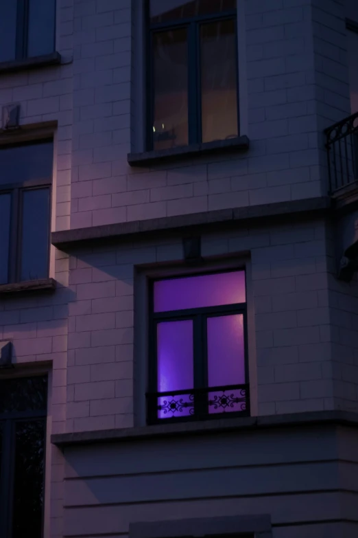 there is a building with a purple light in the window