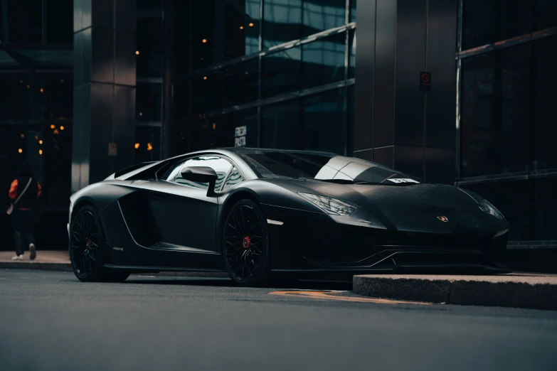 a black sport car parked next to a tall building