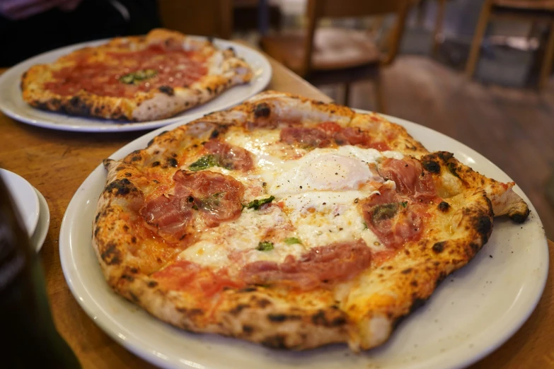 a pizza with toppings is on two separate plates