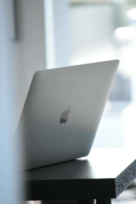 an apple laptop computer sitting on top of a wooden desk