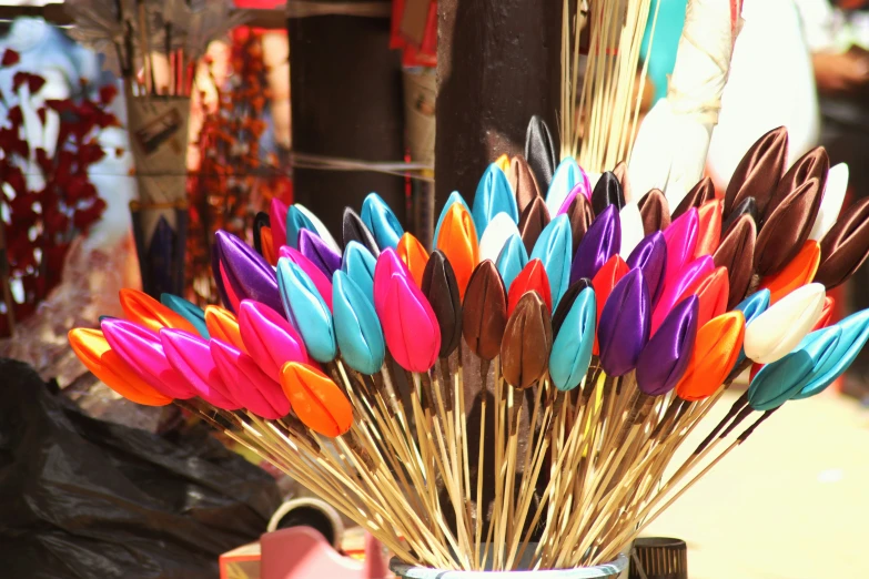 a glass with colorful feathers inside of it