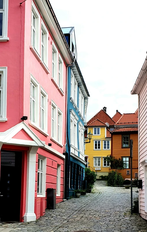 a row of buildings with red doors, on the side walk