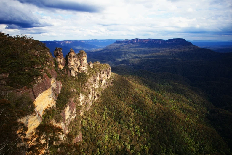 a very tall cliff that is sitting in the middle of some trees