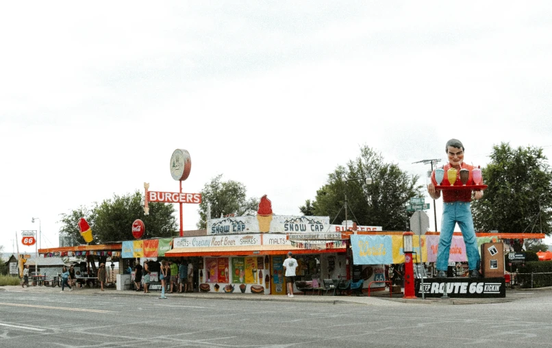 a man in jeans and a hat standing on a stand next to a road