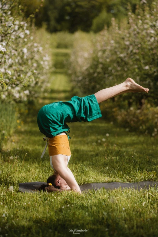 a young man doing a yoga position on his back in the grass