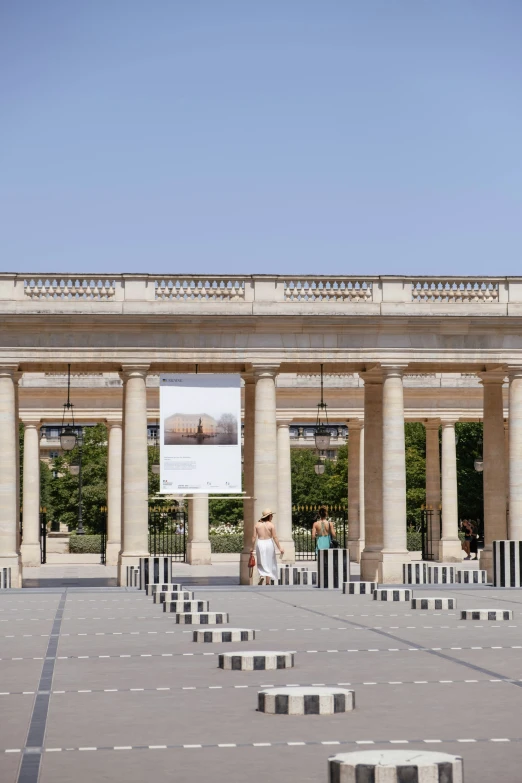 people in a courtyard are walking near two pillars