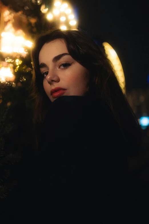 a woman standing outside at night with her phone up