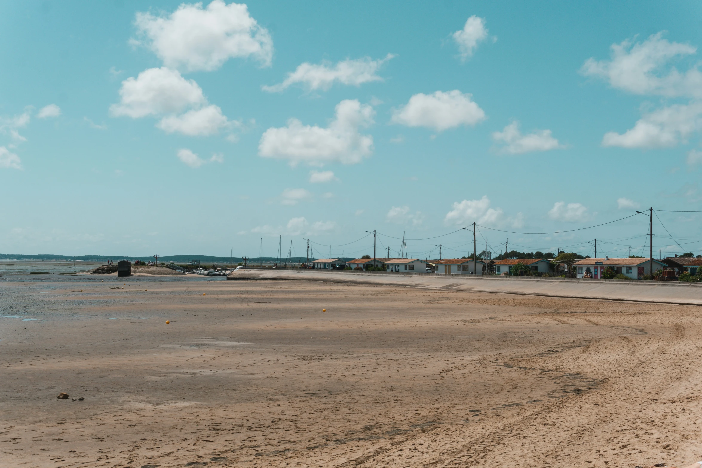 an empty dirt road on a beach next to the ocean